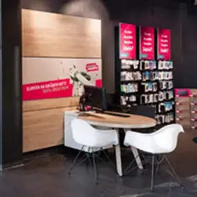 Moderner Empfangsbereich im Büro mit Schreibtisch, Stühlen und Prospektwand