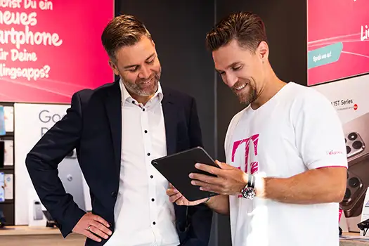 Telekom Mitarbeiter berät Kunden im Shop am Tablet zu Smartphone Tarifen